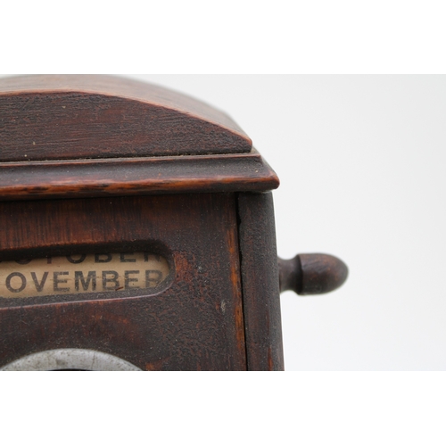 25A - An Edwardian oak perpetual calendar cum desk tidy, with central clock to calendar and scrolling days... 