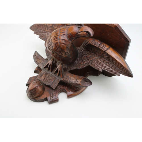 17 - A Victorian carved wall shelf in the form of an eagle facing left, black forest style, 50cm wide, wi... 