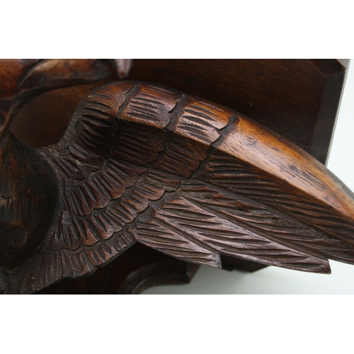 17 - A Victorian carved wall shelf in the form of an eagle facing left, black forest style, 50cm wide, wi... 