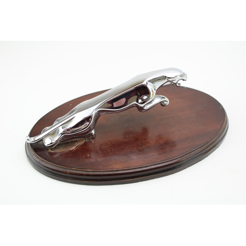 34 - Original Jaguar car mascot mounted on oval plinth, 25.5cm wide, 16cm deep, 9cm tall.