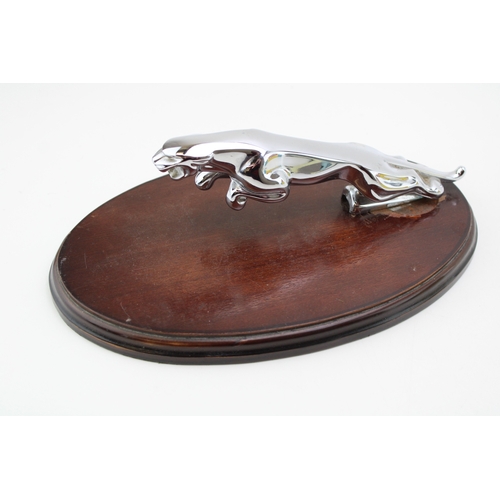 34 - Original Jaguar car mascot mounted on oval plinth, 25.5cm wide, 16cm deep, 9cm tall.