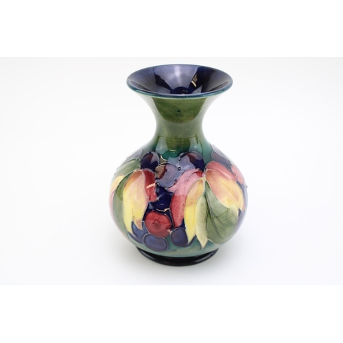 305 - Moorcroft 'Leaf and Berries' pattern vase, green ground with blue inner glaze, 12.5cm tall.