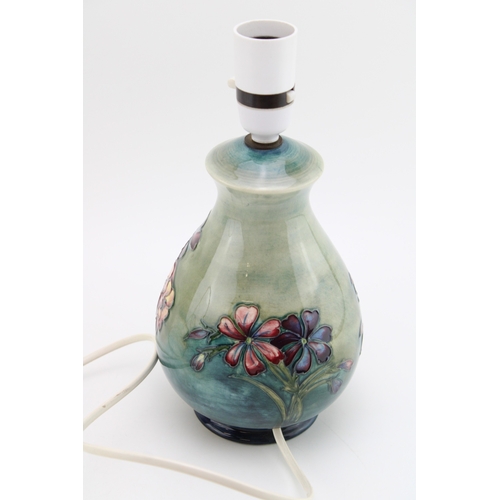 307 - Moorcroft lampbase with floral decoration on green background, 20cm tall.