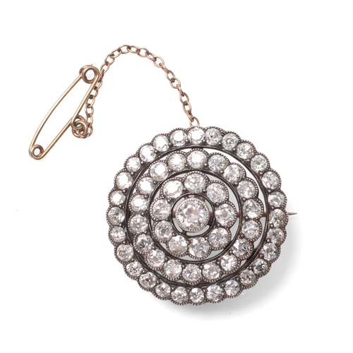 A diamond set, metamorphic target brooch, the central diamond of almost 0.5ct, approximately 4.9mm diameter, surrounded by a circle of nine diamonds each approximately 0.17ct, 3.5mm diameter, a further circle of eighteen very slightly smaller diamonds approximately 0.1ct, 3.0mm diameter, and an outer circle of twenty seven diamonds of 0.08ct, 2.8mm, total diamond weight approximately 6ct, set in unmarked 9ct gold and silver, total weight 9.6g.
