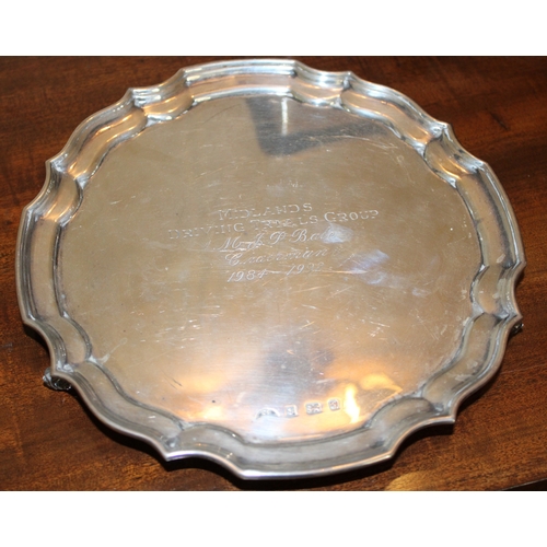 A silver salver with pie-crust edge, raised on three feet, Birmingham 1992, with dedication, 305.8g.