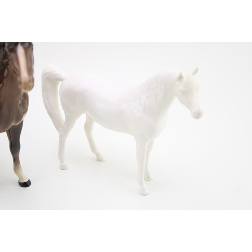 21 - Three Beswick horses to inclue a brown swishtail, an overpainted 'opaque' Arab Xayal and a black / b... 