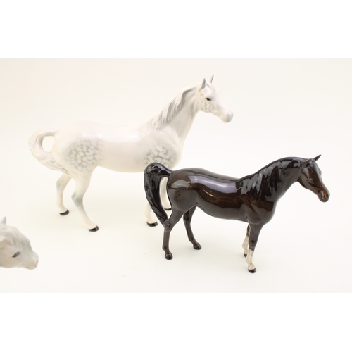39 - Beswick horses to include a grey swishtail, a brown arab xayal and a grey Shetland (3).