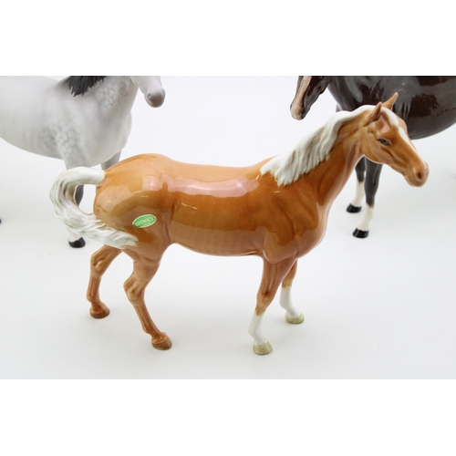 57 - Beswick Swishtail horses to include palomino and matt grey with a brown bois roussell (3).