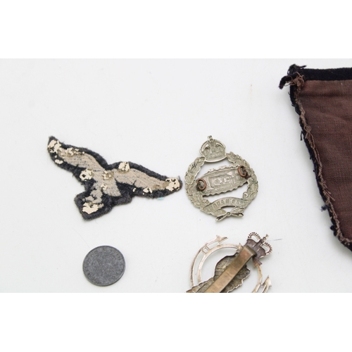 26 - A collection of WW1 & WW2 Royal Armoured Corps metal cap badges with a quality bullion embroidered T... 