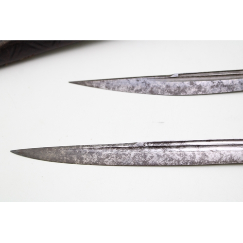 28 - A pair of horn or bone handled eating knives in a leather scabbard.