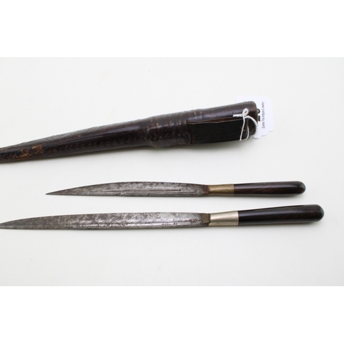 28 - A pair of horn or bone handled eating knives in a leather scabbard.