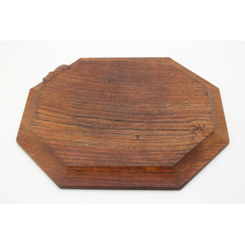 42 - Workshop of Robert 'Mouseman' Thompson, a carved oak breadboard, of octagonal form, with canted corn... 