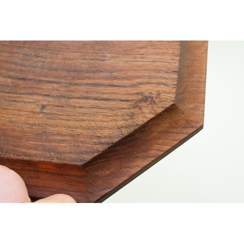 42 - Workshop of Robert 'Mouseman' Thompson, a carved oak breadboard, of octagonal form, with canted corn... 