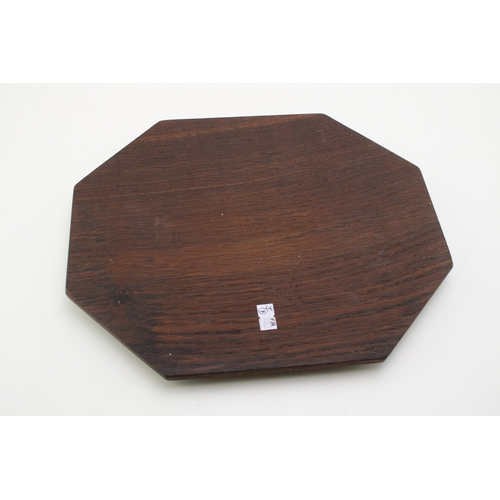 42 - Workshop of Robert 'Mouseman' Thompson, a carved oak breadboard, of octagonal form, with canted corn... 