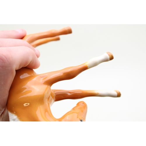 317 - Beswick palomino horses to include a leg tucked horse and three foals (4).