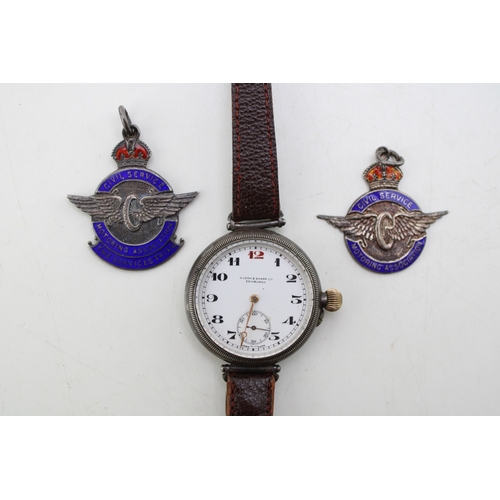 An early 20th century Longines trench wristwatch with silver case retailer Wilson & Sharp Edinburgh to the enamel dial incribed Archd (Archibald) D. Cram Sept 1929 with two Civil Service Motoring Association Services Trial enamel silver medal fobs to A.D. Cram 1932 & 1935