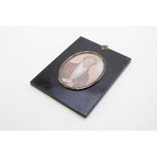 11 - A mid 19th century portrait miniature of a gentleman holding a letter, of oval form delicately paint... 