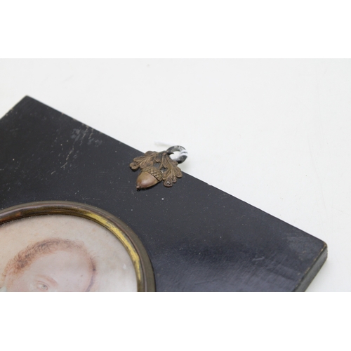 11 - A mid 19th century portrait miniature of a gentleman holding a letter, of oval form delicately paint... 