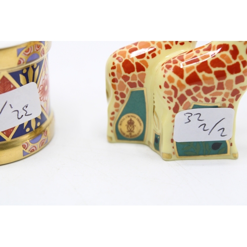 59 - Two boxed Royal Crown Derby paperweights to include a pair of giraffes and a toy drum with drumstick... 
