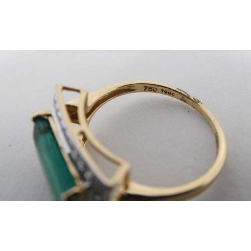 1012 - An 18ct gold ring set with central emerald bordered by diamonds.