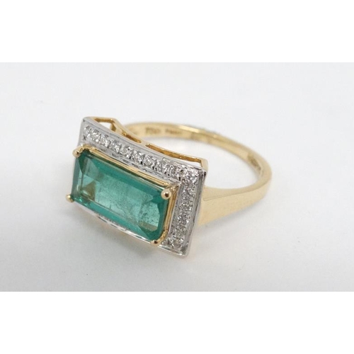 1012 - An 18ct gold ring set with central emerald bordered by diamonds.