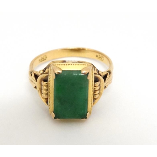 1013 - A Chinese 22ct gold ring set with jade like hardstone stone to top