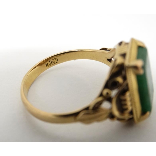 1013 - A Chinese 22ct gold ring set with jade like hardstone stone to top