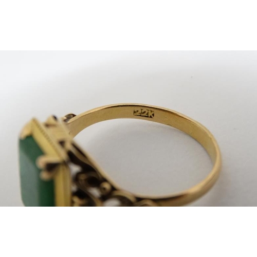 1013 - A Chinese 22ct gold ring set with jade like hardstone stone to top