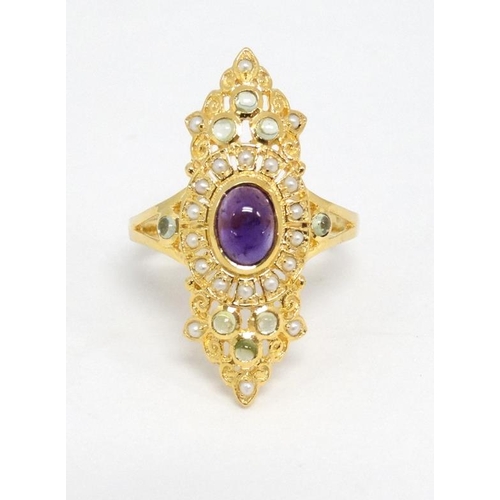 1014 - A silver gilt ring set with amethyst cabochon to centre  and a profusion of peridot and seed pearls ... 