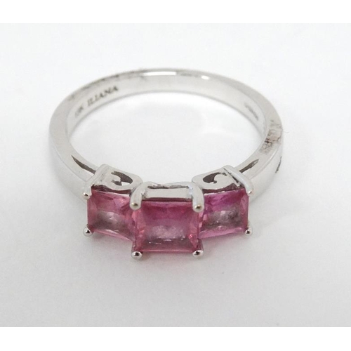 1019 - An 18ct white gold ring set with three pink sapphires.