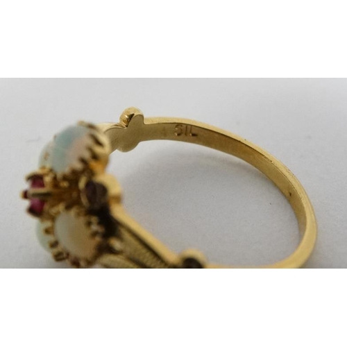 1020 - A silver gilt ring set with opal like cabochon and red stones. Marked 'Sil'