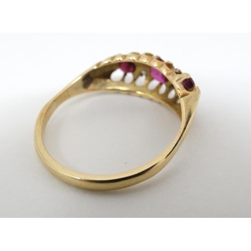 1024 - An 18ct gold ring set with central ruby flanked by 2 garnets and white stones