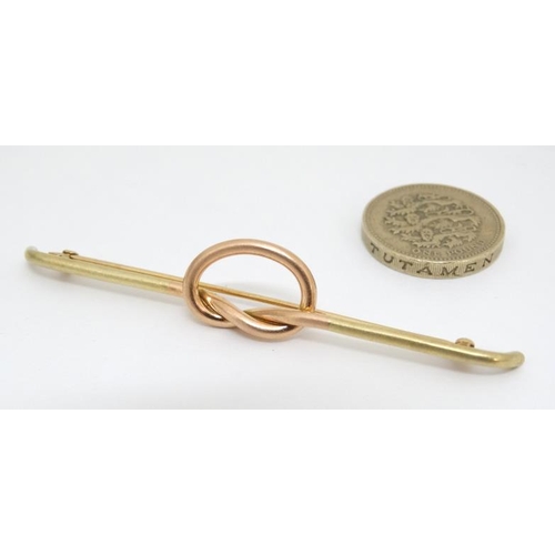 1027 - A 14kt gold bar brooch with rose gold knot decoration to centre. Marked Tiffany & Co.  3'' wide