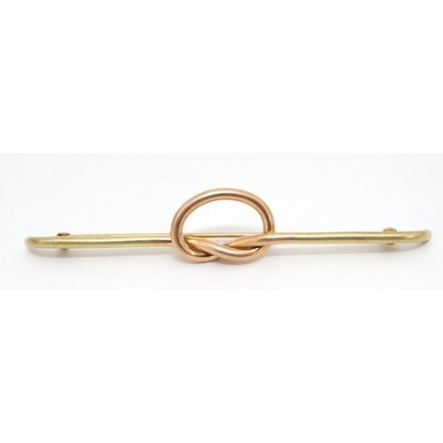 1027 - A 14kt gold bar brooch with rose gold knot decoration to centre. Marked Tiffany & Co.  3'' wide