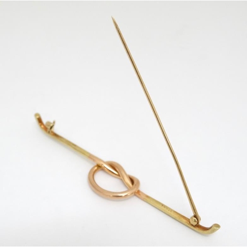 1027 - A 14kt gold bar brooch with rose gold knot decoration to centre. Marked Tiffany & Co.  3'' wide