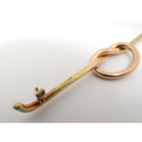 1027 - A 14kt gold bar brooch with rose gold knot decoration to centre. Marked Tiffany & Co.  3'' wide