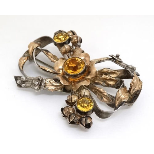 1029 - American Vintage Costume Jewelery by Hobé : A silver and gold plated brooch of stylised bow and flow... 