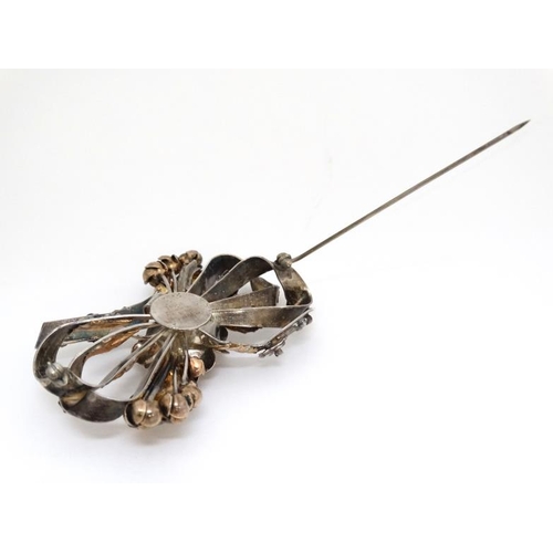 1029 - American Vintage Costume Jewelery by Hobé : A silver and gold plated brooch of stylised bow and flow... 