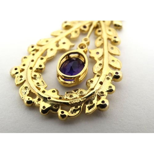 1030 - A silver gilt pendant set with amethyst and peridot. 1 ¾'' long