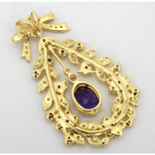 1030 - A silver gilt pendant set with amethyst and peridot. 1 ¾'' long