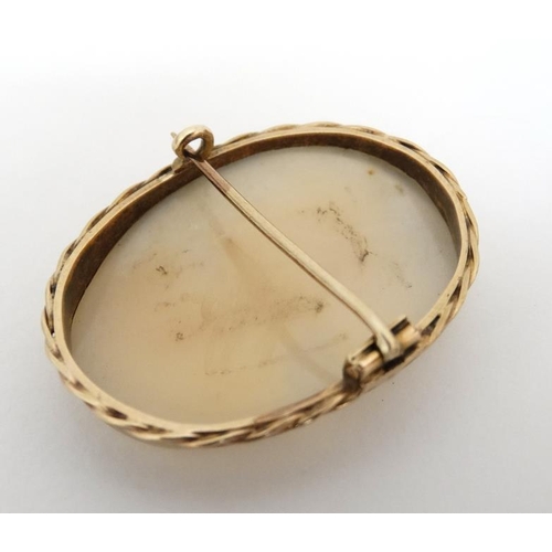 1033 - A cameo brooch set with classic oval cameo within a yellow metal mount. The whole 1 ½'' high