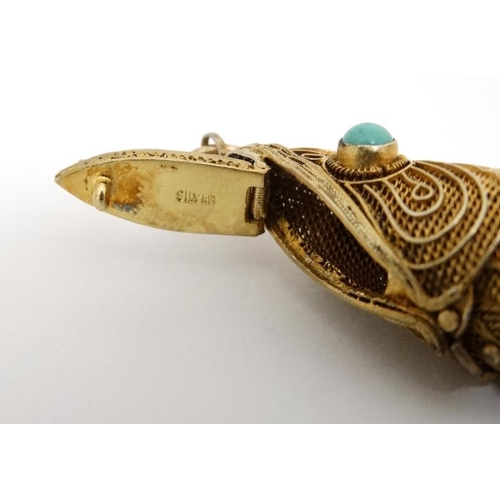 1041 - A silver gilt pendant / vinaigrette formed as an articulated fish set with turquoise cabochon. 2 ¾''... 