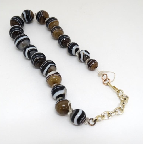 1051 - A string of graduated banded agate beads. Approx 12'' long