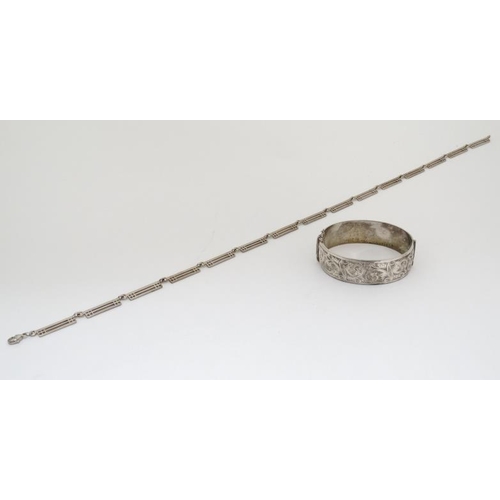 1061 - A hallmarked silver bangle formed bracelet with engraved acanthus scroll decoration together with a ... 