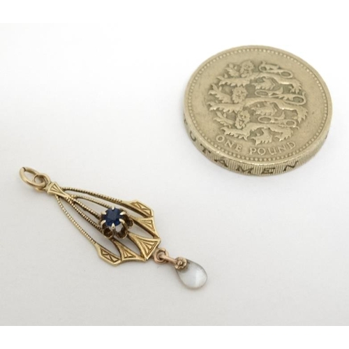 1063 - A gilt metal pendant set with central blue stone and mother of pearl drop . approx. 1'' long