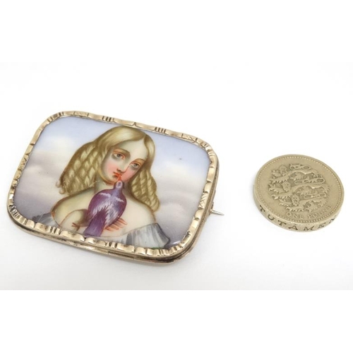 1064 - A yellow metal brooch set with hand painted ceramic panel depicting a young girl holding a dove. App... 