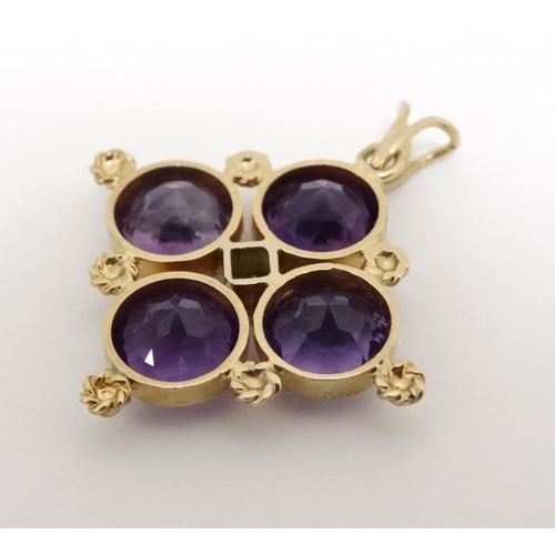 1077 - A yellow metal quatreform pendant set with four amethysts and central diamond. Marked K18  1'' long