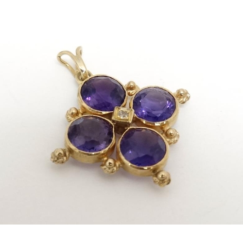 1077 - A yellow metal quatreform pendant set with four amethysts and central diamond. Marked K18  1'' long