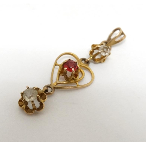 1081 - A yellow metal pendant with open work heart decoration set with red and white stones. 1 ¼'' long