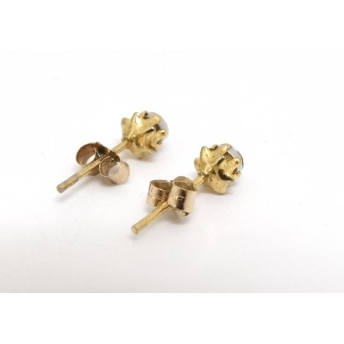 1082 - A pair of gilt metal stud earrings set with illusion set white stones.